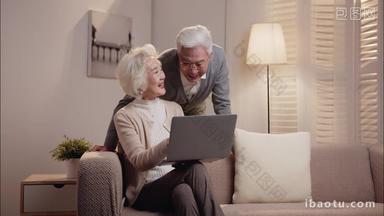 老年夫妇坐在沙发上使用笔记本<strong>电脑</strong>